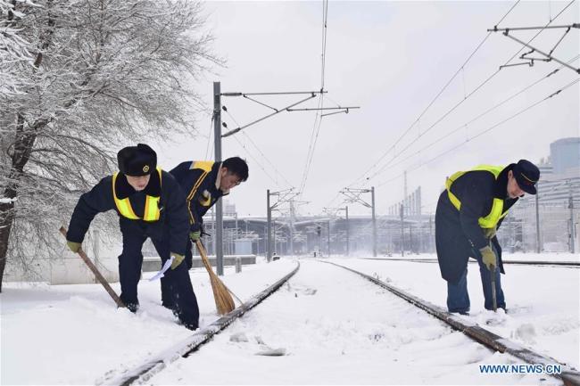 Workers remove snow from train tracks at Shenyang North Railway Station in Shenyang, northeast China's Liaoning Province, March 15, 2018. [Photo: Xinhua]