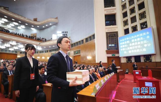 Staff members prepare to distribute vote papers at the seventh plenary meeting of the first session of the 13th National People's Congress (NPC) at the Great Hall of the People in Beijing, capital of China, March 19, 2018. [Photo: Xinhua] 