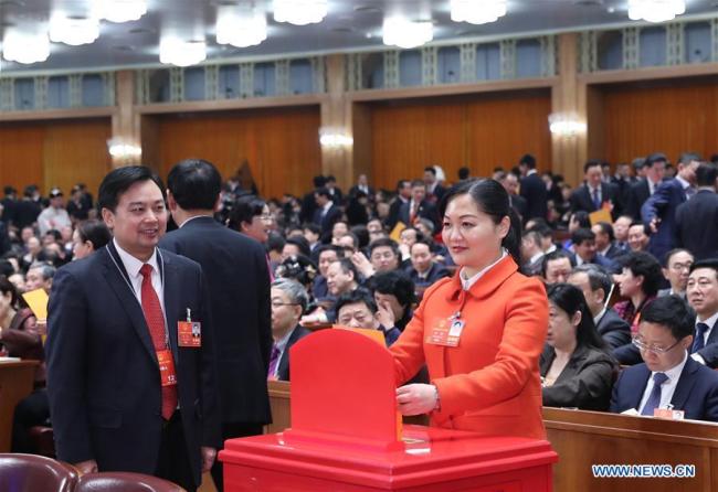A deputy to the 13th National People's Congress (NPC) casts her vote paper at the seventh plenary meeting of the first session of the 13th NPC at the Great Hall of the People in Beijing, capital of China, March 19, 2018. [Photo: Xinhua]