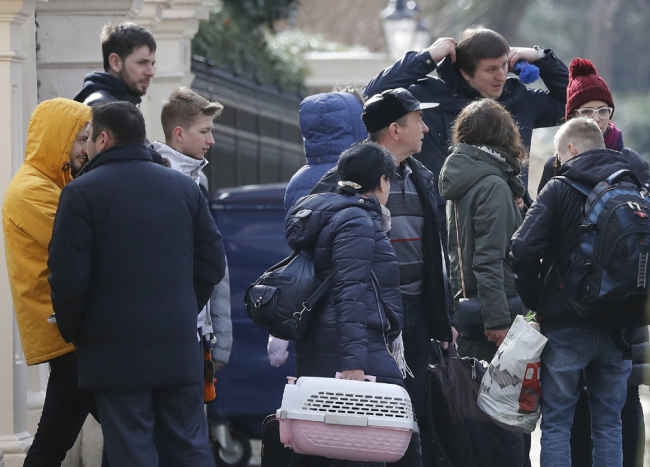 People with suitcases leave the Russian Embassy in London, Tuesday, March 20, 2018. Moscow is awaiting nearly two dozen Russian diplomats ordered to leave Britain as part of a standoff over a nerve agent attack on British soil. [Photo: AP/Frank Augstein]
