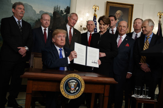 President Donald Trump shows off a signed Presidential Memorandum imposing tariffs and investment restrictions on China, in the Diplomatic Reception Room of the White House, Thursday, March 22, 2018, in Washington. [Photo: AP]
