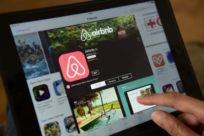 Photo taken on April 28, 2016 shows a man browsing the site of US home sharing giant Airbnb on a tablet. [File Photo: VCG]