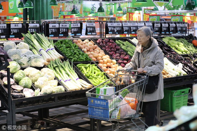 A citizen buys vegetables in a supermarket in Harbin, April 10, 2018. [Photo: VCG]