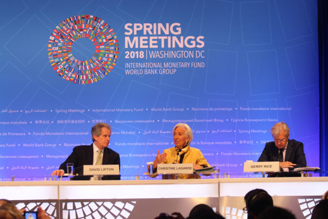Christine Lagarde (center), managing director of the International Monetary Fund, talks to reporters at a press conference during the 2018 IMF spring meetings. [Photo: China Plus/Liu Kun]