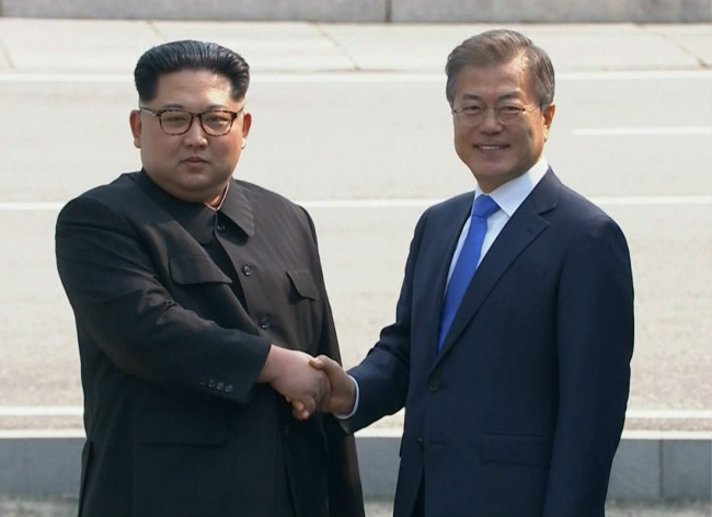 In this image taken from video provided by Korea Broadcasting System, April 27, 2018, North Korean leader Kim Jong Un, left, shakes hands(握手) with South Korean President Moon Jae-in as Kim crossed the border into South Korea for their historic face-to-face talks, in Panmunjom. [Photo: AP]