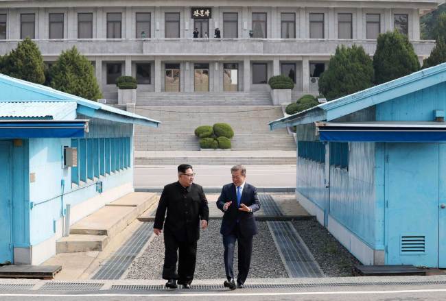 North Korean leader Kim Jong Un, left, listens to South Korean President Moon Jae-in while walking together at the Panmunjom in the Demilitarized Zone Friday, April 27, 2018. [File photo: AP]