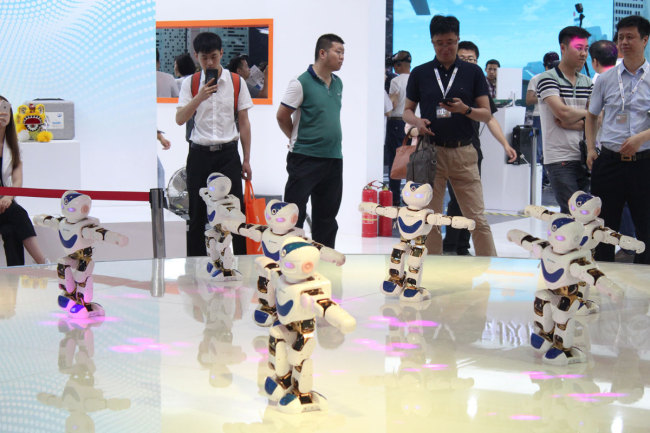 Robots are dancing to the music at the World Exhibition of Intelligent Technology on May 16, 2018. [Photo: China Plus/Guo Jing]