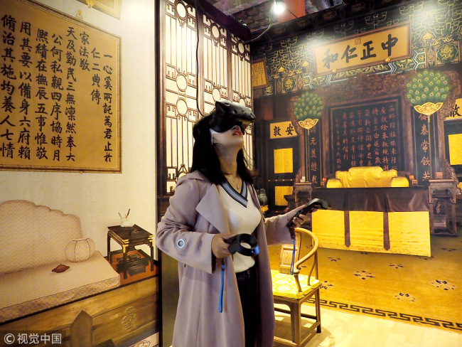 A visitor experiences the heyday of the Forbidden City through VR at a digital exhibition in the Palace Museum. [File photo: VCG]
