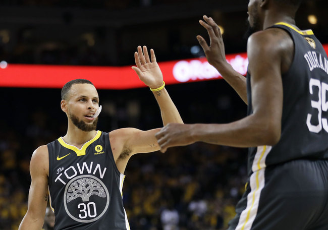 Golden State Warriors guard Stephen Curry (30) celebrates with forward Kevin Durant during the first half of Game 2 of basketball's NBA Finals against the Cleveland Cavaliers in Oakland, Calif., Sunday, June 3, 2018. [Photo: AP]