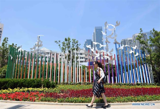 A woman walks past an installation in Qingdao, east China's Shandong Province, June 3, 2018. The 18th Shanghai Cooperation Organization (SCO) Summit is scheduled for June 9 to 10 in Qingdao. [Photo: Xinhua]