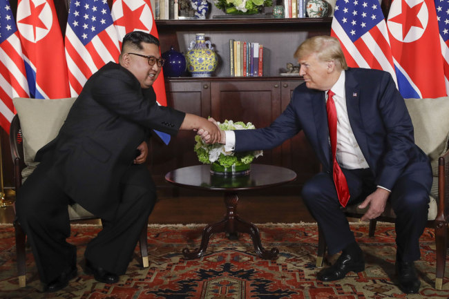 U. S. President Donald Trump shakes hands with North Korea leader Kim Jong Un during their first meetings at the Capella resort on Sentosa Island Tuesday, June 12, 2018 in Singapore. [Photo: AP]