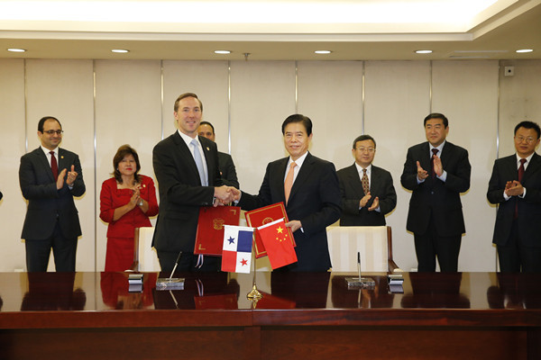 Chinese Minister of Commerce Zhong Shan (front, right) and Panamanian Minister of Trade and Industry Augusto Arosemena shake hands after signing a memorandum of understanding in Beijing on June 12, 2018. [Photo: Chinese Ministry of Commerce]