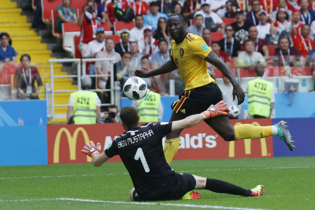 Belgium's Romelu Lukaku , right, scores their side's third goal past Tunisia goalkeeper Farouk Ben Mustapha during the group G match between Belgium and Tunisia at the 2018 soccer World Cup in the Spartak Stadium in Moscow, Russia, Saturday, June 23, 2018. [Photo: AP/Hassan Ammar]