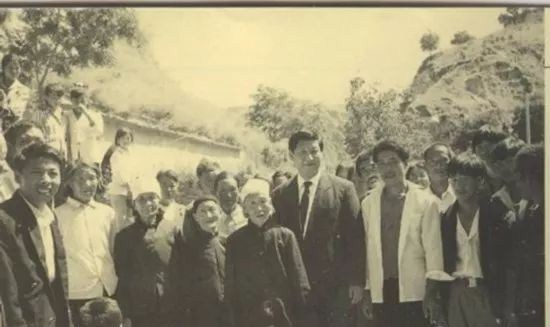 Xi Jinping visits and poses for a photo with local folk at Liangjiahe Village in northwest China’s Shaanxi Province in 1993. [File photo: cctv.com]