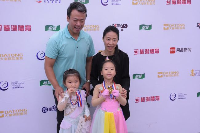 China's former Olympian medalist pair Zhao Hongbo[L] and Shenxue [R]take photos with their five-year-old daughter Zhao Xuer at Tus ice and snow sports center in Beijing on July 1, 2018. [Photo: China Plus/ Wangbo Malonsports ]