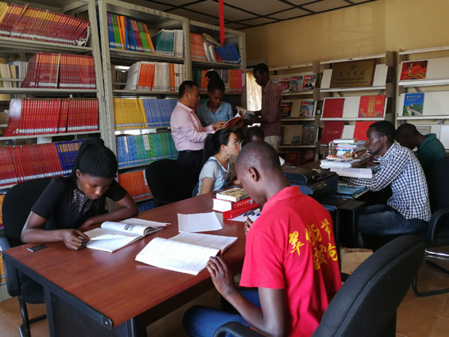 Students and teachers from the Confucius Institute at the University of Rwanda exchange ideas in the Chinese reading room.[Photo:China Plus]