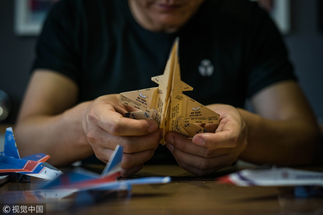 Liu Dong makes paper planes. [Photo/VCG]