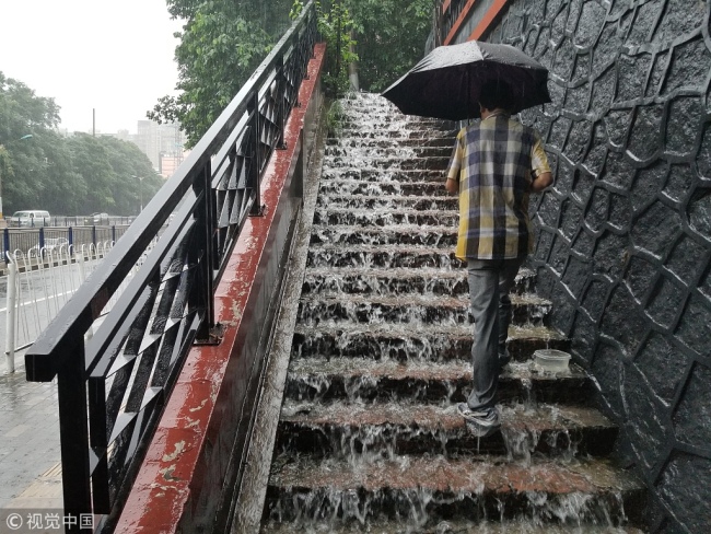 Heavy downpours brought on the remanence of tropical storm Ampil pounded Beijing and neighboring through early Tuesday, causing flight delays and evacuations. Beijing issued a yellow warning for heavy rain on Tuesday morning. [Photo: VCG]
