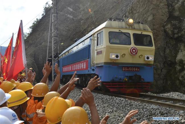 A train passes through a section of the Baoji-Chengdu railway repaired after it was blocked by rain-triggered landslides in Lueyang County, northwest China's Shaanxi Province, July 28, 2018. [Photo: Xinhua]