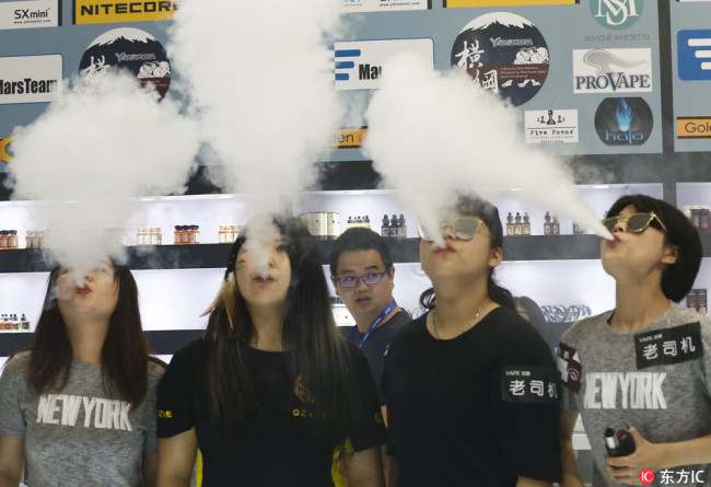 People use e-cigarettes at an exhibition center in Beijing on July 29, 2016. [File photo: IC]