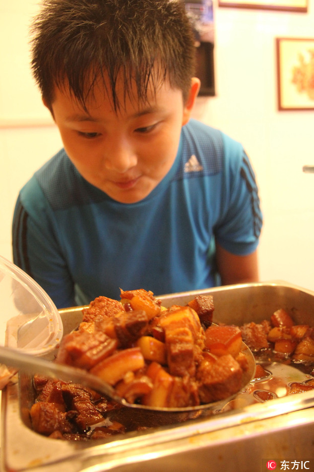 A young customer buys braised pork for "Autumn Fleshing Out," August 7, 2016. [File Photo: IC]