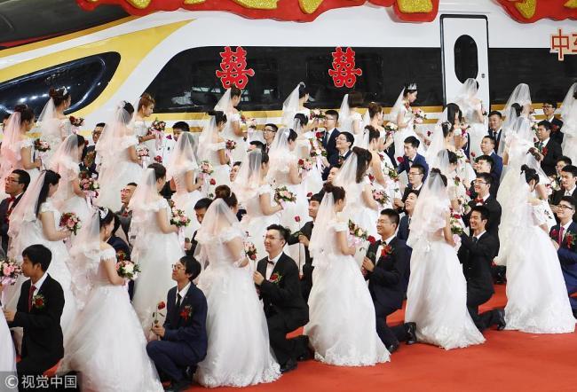 A group wedding is held at a manufacturing workshop(车间) of the Changchun Railway Vehicles in Jilin Province on August 18. [Photo: VCG]