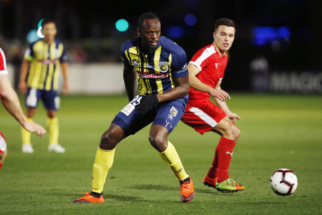 Usain Bolt runs the ball during a friendly trial match between the Central Coast Mariners and the Central Coast Select in Gosford, Australia, Friday, Aug. 31, 2018. Bolt, who holds the world records for the 100- and 200-meter sprints and is an eight-time Olympic gold medalist, is hoping to earn a contract with the Mariners for the 2018-19 season in Australia's top-flight competition. [Photo: AP/Steve Christo]
