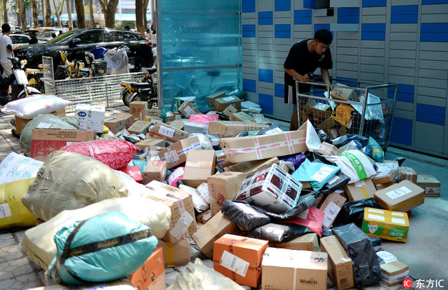 A courier puts parcels into delivery lockers at a university in Jinan in Shandong Province on Saturday, September 1, 2018. [Photo: IC]