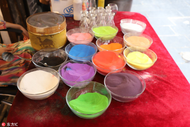 Colored sand and tools are seen at the shop. [Photo/IC]