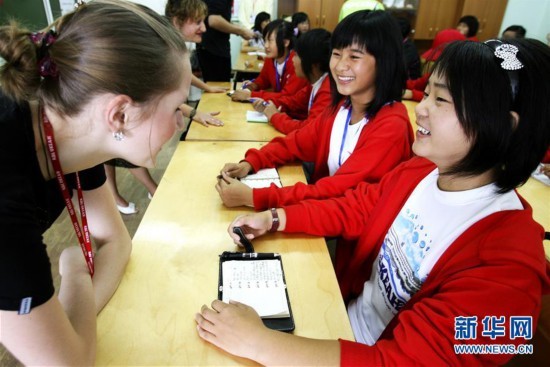 A Russian teacher (left) helps two Chinese students to practice oral speaking skills at the Ocean All-Russia Children's Care Center in Vladivostok, Russia on July 22, 2008. [Photo: Xinhua/Zhengyue]
