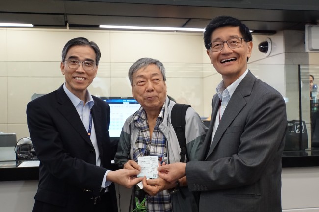 A citizen surnamed Liang (C) who bought the first ticket poses a photo with MTR CEO Lincoln Leong Kwok-kuen (R) and MTR Operations Director Adi Lau Tin-shing (L) at the West Kowloon railway station in Hong Kong, China, September 10, 2018. [Photo: China Plus/Li Naxin]