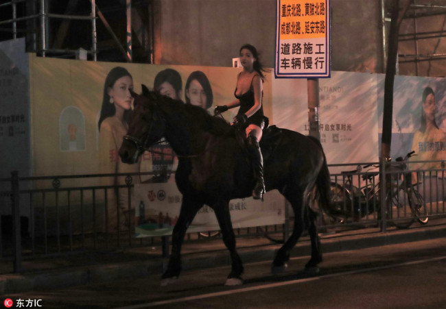 A woman is seen riding a horse on the main road of Shanghai, September 11, 2018. [Photo: IC]