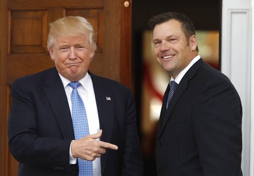 FILE - In this Nov. 20, 2016, file photo, ,President-elect Donald Trump greets Kansas Secretary of State, Kris Kobach, as he arrives at the Trump National Golf Club Bedminster clubhouse in Bedminster, N.J. Kobach, a Republican candidate for Kansas governor, says Kansas is spending $377 million a year on benefits for immigrants living in the U.S illegally, and he promises to put a stop to it if he's elected governor. [Photo: AP/Carolyn Kaster]