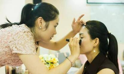Xiao Jia teaches her students about doing makeups during a class. [File photo: ynet.com]