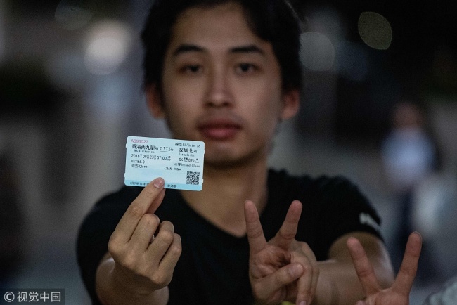 Tony Chan displays the ticket from one of the first trains to Shenzhen to the media during the first public service day of Guangzhou–Shenzhen–Hong Kong Express Rail Link (XRL) in Hong Kong on September 23, 2018. [Photo: VCG]