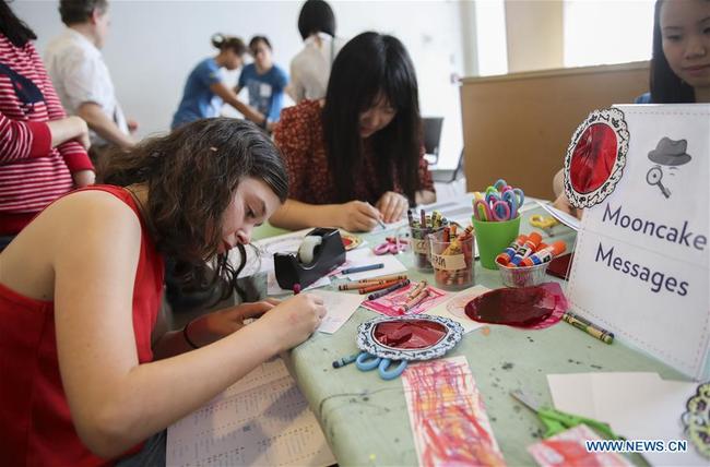 Children write mooncake messages during the Mid-Autumn Moon Family Festival event held at the Museum of Chinese in America (MOCA) in New York, the United States, Sept. 22, 2018. [Photo: Xinhua] 