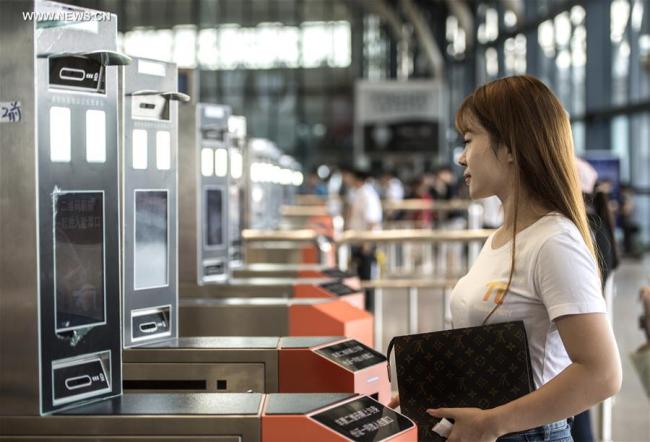 A passenger uses her identification card at a facial recognition scanner as she prepares to board a train at Wuhan Railway Station in Hubei Province on August 22, 2017. [Photo: Xinhua]