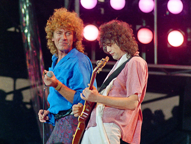 In this July 13, 1985 file photo, Led Zeppelin bandmates, singer Robert Plant, left, and guitarist Jimmy Page, reunite to perform for the Live Aid famine relief concert at JFK Stadium in Philadelphia. [Photo: AP/Amy Sancetta]