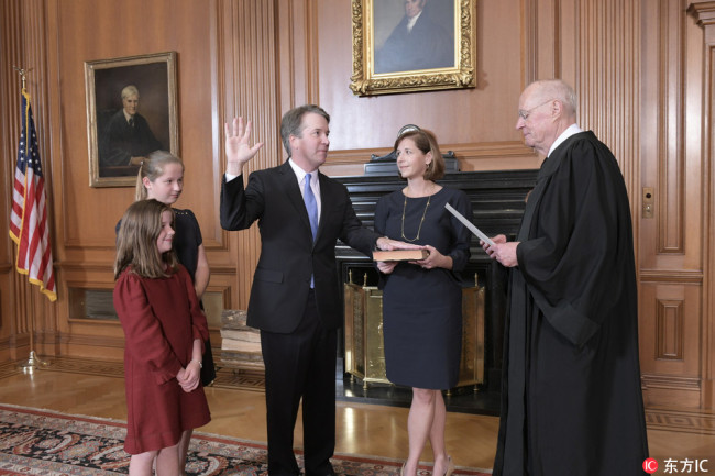 A handout photo made available by the US Supreme Court shows retired Supreme Court Justice Anthony M. Kennedy (R), administering the Judicial Oath to Judge Brett M. Kavanaugh (C-L) in the Justices' Conference Room of the Supreme Court in Washington, DC, USA, 06 October 2018. [Photo: IC]