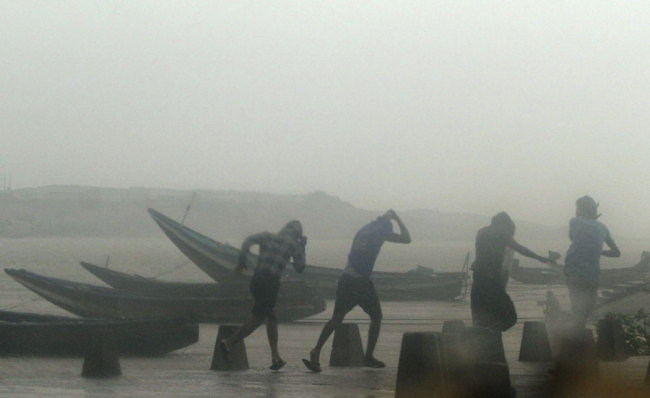 Indian fishermen prepare to leave the beach during rain and strong winds caused by cyclonic storm named Titli, or Butterfly near Gopalpur on the Bay of Bengal coast, Ganjam district, eastern Orissa state, India, Thursday, Oct.11, 2018. The severe cyclone damaged mud huts and uprooted trees and electric poles Thursday in eastern India where authorities have moved nearly 300,000 people to higher ground. [Photo: AP]