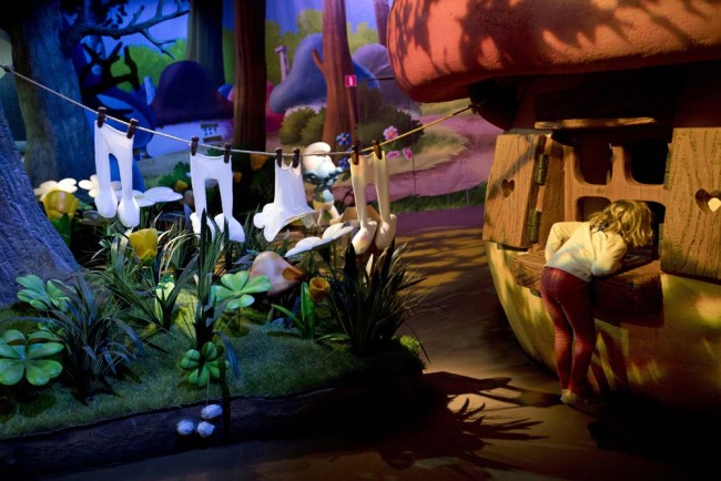 A child peeks inside a Smurfs house during the Smurfs exhibition marking the 60th anniversary of their creation by Belgium cartoonist Pierre Culliford, known as Peyo, in Brussels, Tuesday, Oct. 23, 2018. [Photo：AP]