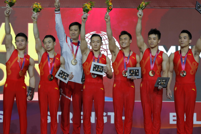 World champion team China with Deng Shudi, Lin Chaopan, Sun Wei, Xiao Ruoteng, Zou Jingyuan and their coach pose with their gold medals during the men's team final of the Gymnastics World Chamionships at the Aspire Dome in Doha, Qatar, Monday, Oct. 29, 2018. [Photo: AP]
