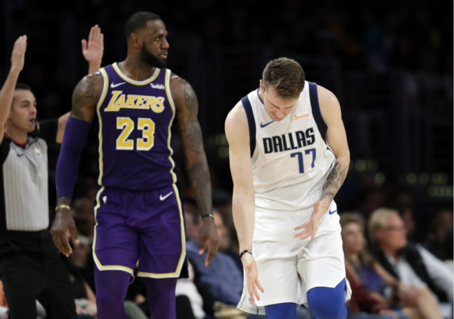 Dallas Mavericks' Luka Doncic (77) reacts after making a 3-point basket next to Los Angeles Lakers' LeBron James (23) during the second half of an NBA basketball game on Wednesday, October 31, 2018, in Los Angeles. [Photo: AP]