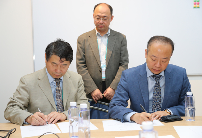 Beijing Hospital Vice President Xu Feng (L) signs a tentative agreement with a representative of Philips to buy medical equipment from the Dutch company at the China International Import Expo in Shanghai on Tuesday, November 6, 2018. [Photo: China Plus]
