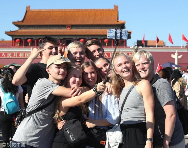 Foreign visitors pose for a group photo at Tian'anmen Square in Beijing, October 3, 2018. [Photo: VCG]
