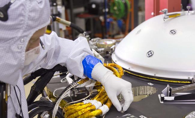 Engineers at NASA's Jet Propulsion Laboratory, Pasadena, California, put the names onto this tiny 0.8 cm-square (8 mm-square) silicon wafer microchip using an electron beam to write extremely tiny letters with lines smaller than one one-thousandth the width of a human hair. [Photo:mars.nasa.gov]