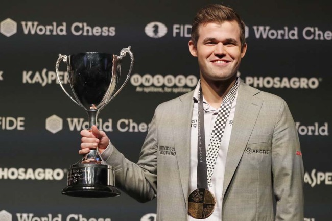 Reigning chess world champion, Norway's Magnus Carlsen celebrates with the trophy after retaining the World chess Championship in London, Wednesday, Nov. 28, 2018. Norwegian grandmaster Magnus Carlsen has defended his chess world championship title by beating American challenger Fabiano Caruana 3-0 in rapid tiebreaker games.[Photo: AP]