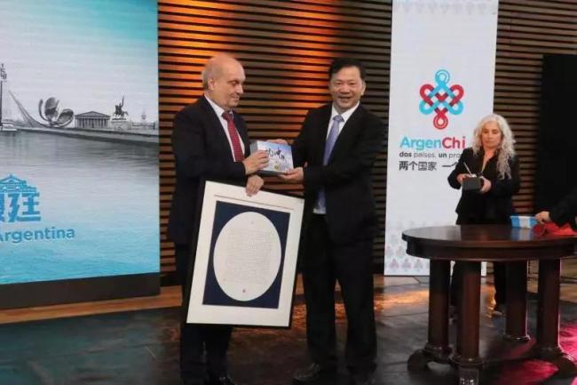 Shen Haixiong, the president of China Media Group, gives Hernan Lombardi a copy of "Aerial China", China's most large-scale 4K aerial documentary as a gift. [Photo: CCTV]