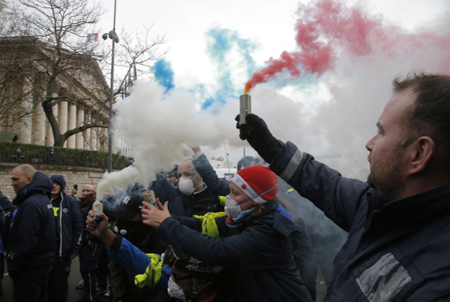 Ambulance workers hold flares outside the National Assembly in Paris, Monday, Dec. 3, 2018. [Photo: AP /Michel Euler]