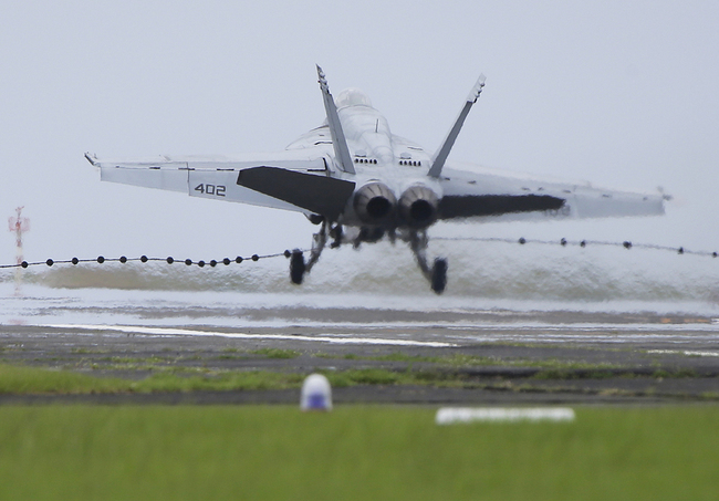 A U.S. Navy F/A-18 Super Hornet catches an arresting wire during an emergency landing after an indicated landing gear failure during training in Iwo Jima, Japan, Friday, June 7, 2013. [File photo: AP/Greg Baker]